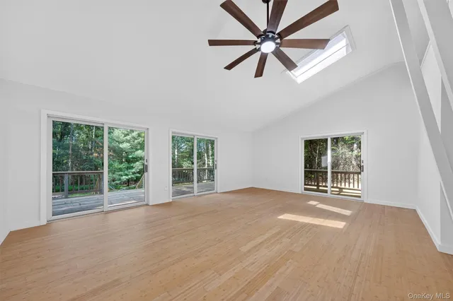 a view of an empty room with a window and a kitchen