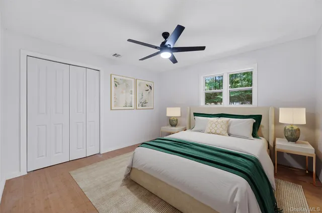 a bedroom with a large bed and a ceiling fan
