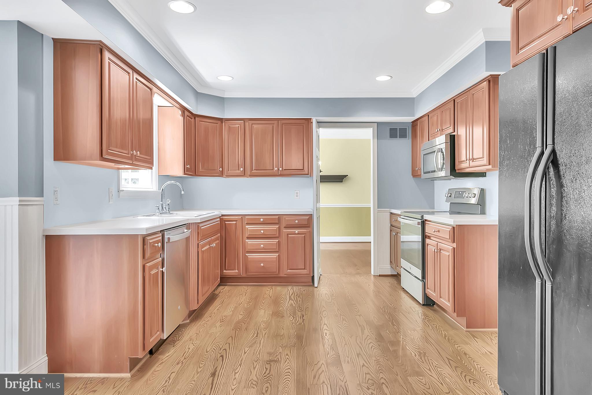 10 New Haven Drive Newark, DE 19713 - Photo 10 of 27 a kitchen with stainless steel appliances granite countertop a refrigerator a sink dishwasher and wooden cabinets with wooden floor