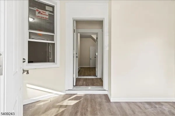 a view of an empty room with closet and mirror