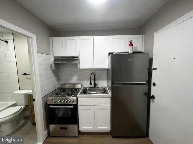 a kitchen with a refrigerator sink and cabinets