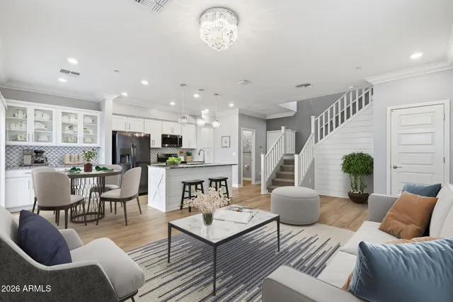a living room with furniture kitchen view and a chandelier
