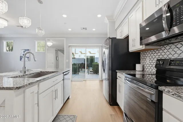 a kitchen with stainless steel appliances granite countertop a sink and a refrigerator