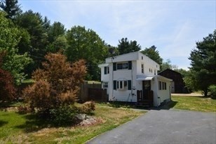 428 Putnam Hill Road Sutton, MA 01590 - Photo 3 of 42 a front view of a house with a yard and garage