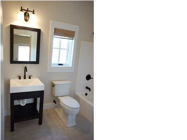 128 Marlin Street Santa Rosa Beach, FL 32459 - Photo 18 of 21 a bathroom with a toilet a sink a mirror and a window