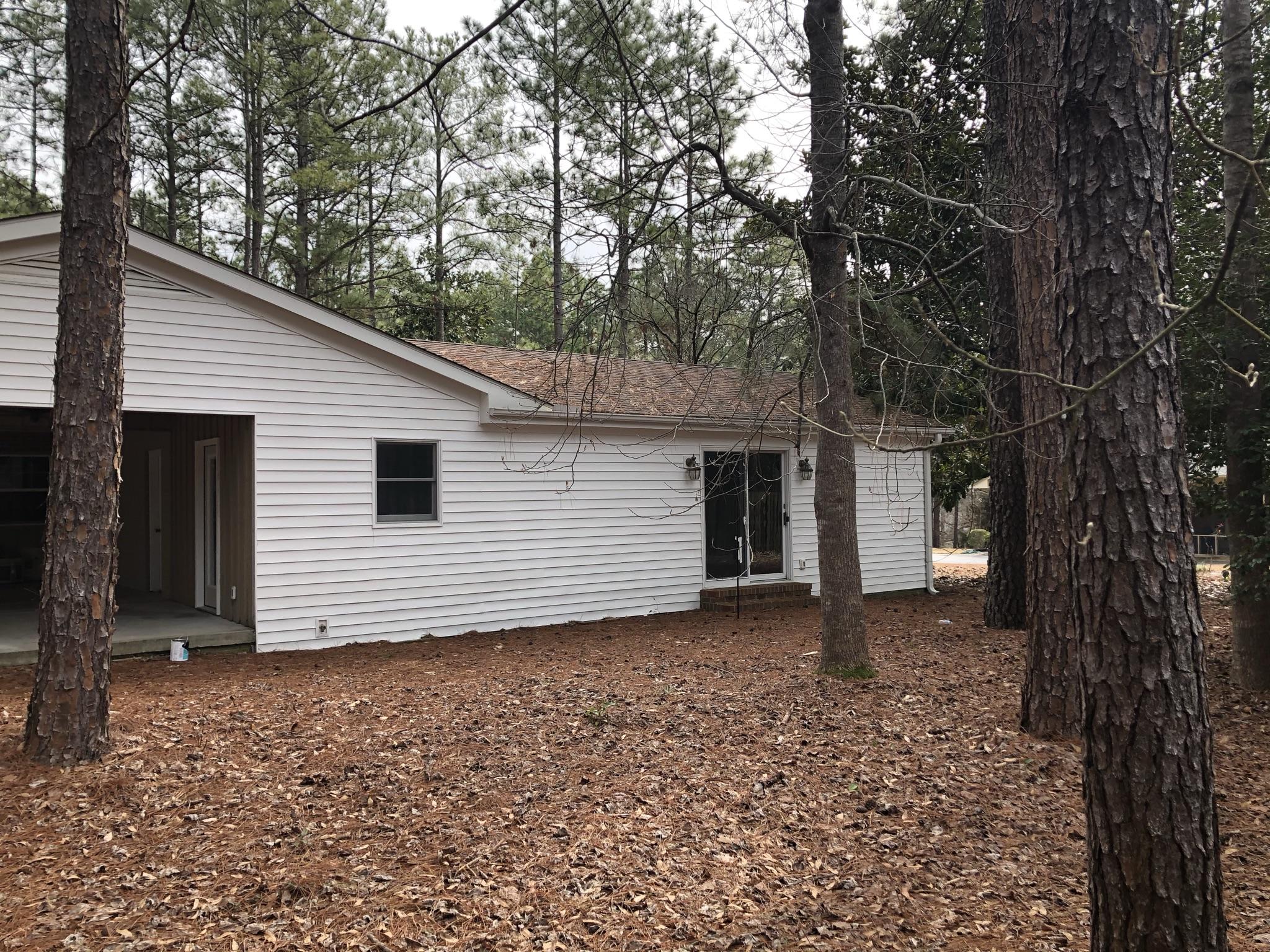 905 Robinwood Road Aberdeen, NC 28315 - Photo 30 of 42 Sliding glass doors from the apartment's living room exit to the wooded back yard