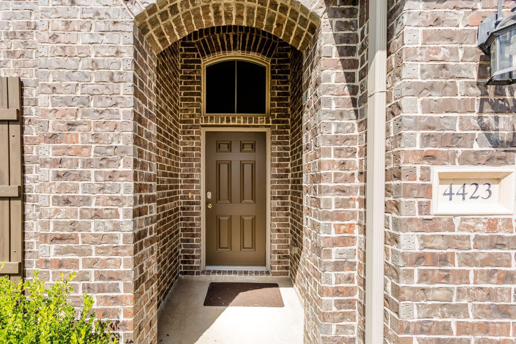 4423 Hidden Oaks Way Houston, TX 77084 - Photo 2 of 29 a view of a door with brick walls