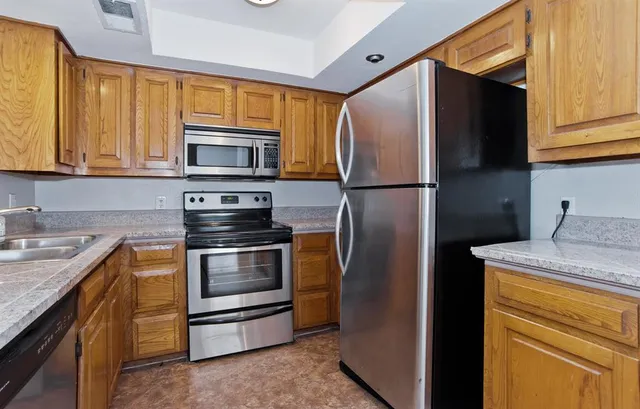 a bathroom with a granite countertop sink a mirror and a shower