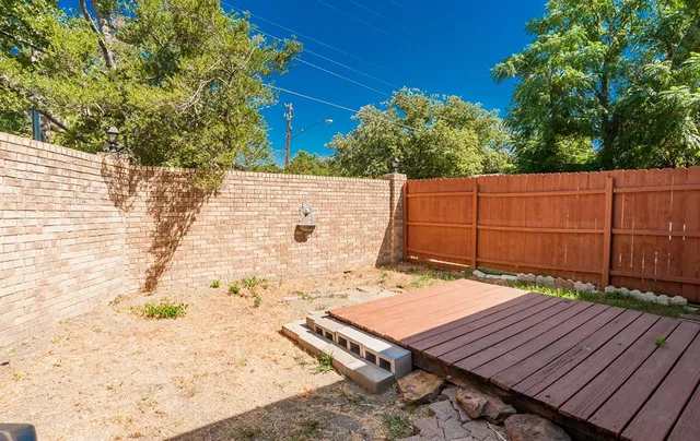 a view of a patio with table and chairs potted plants and large tree