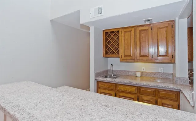 a kitchen with granite countertop a sink and a refrigerator
