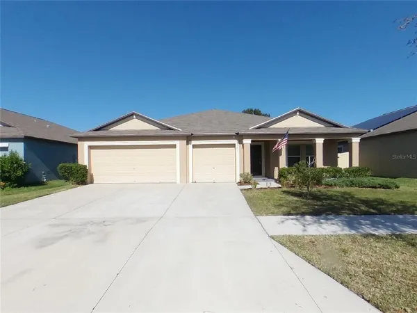 a front view of a house with yard and parking