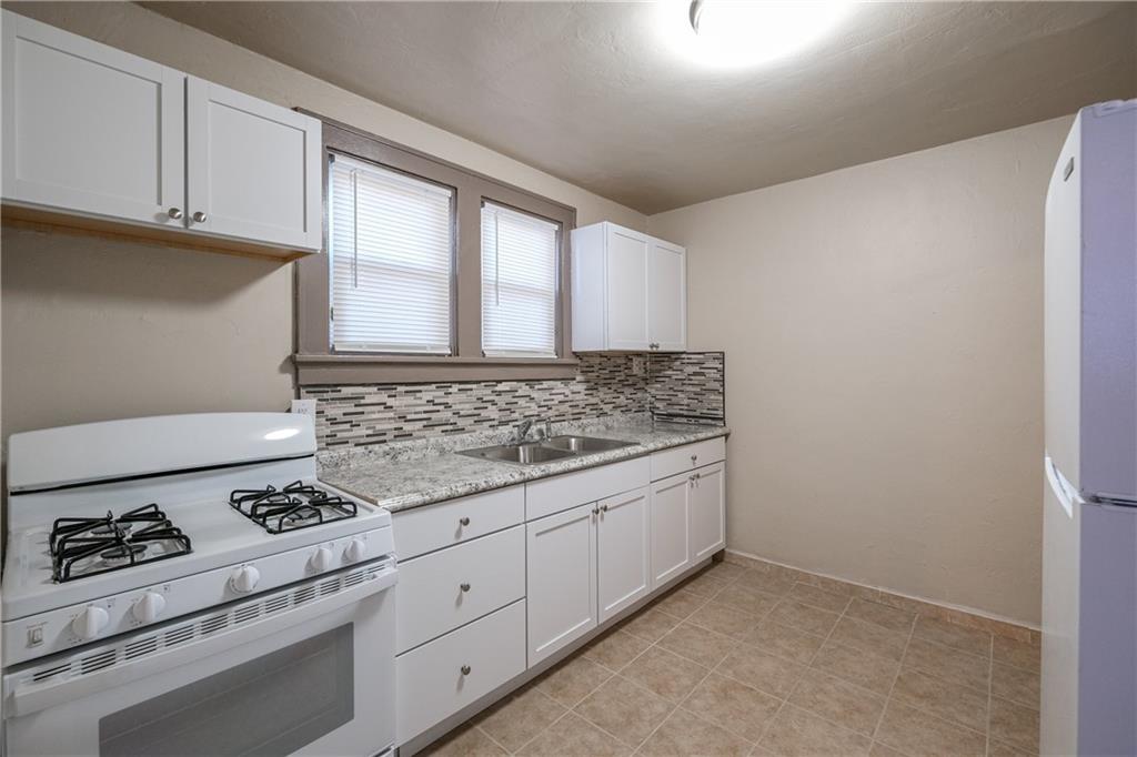 1326 Woodland Avenue Pittsburgh, PA 15212 - Photo 7 of 16 a kitchen with granite countertop cabinets and white appliances