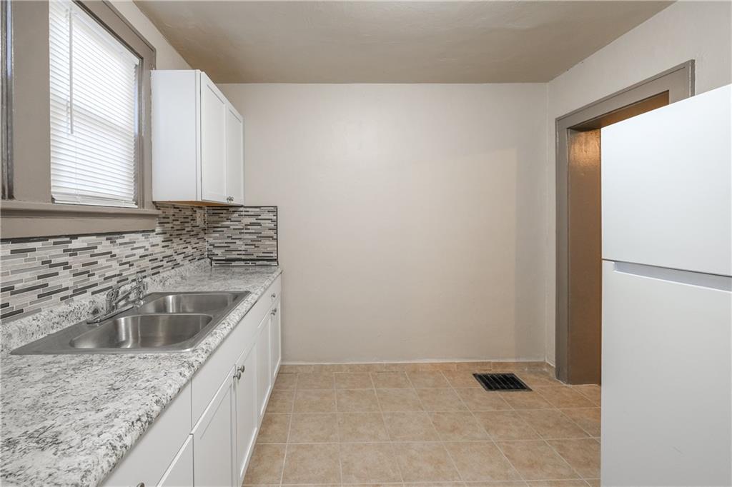 1326 Woodland Avenue Pittsburgh, PA 15212 - Photo 8 of 16 a kitchen with granite countertop a sink and a refrigerator