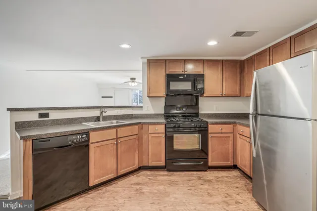 a kitchen with stainless steel appliances granite countertop a refrigerator stove and sink