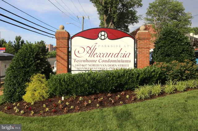 a sign that is sitting on a brick wall in front of a building