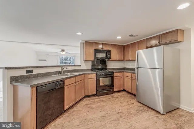 a kitchen with a sink refrigerator and cabinets