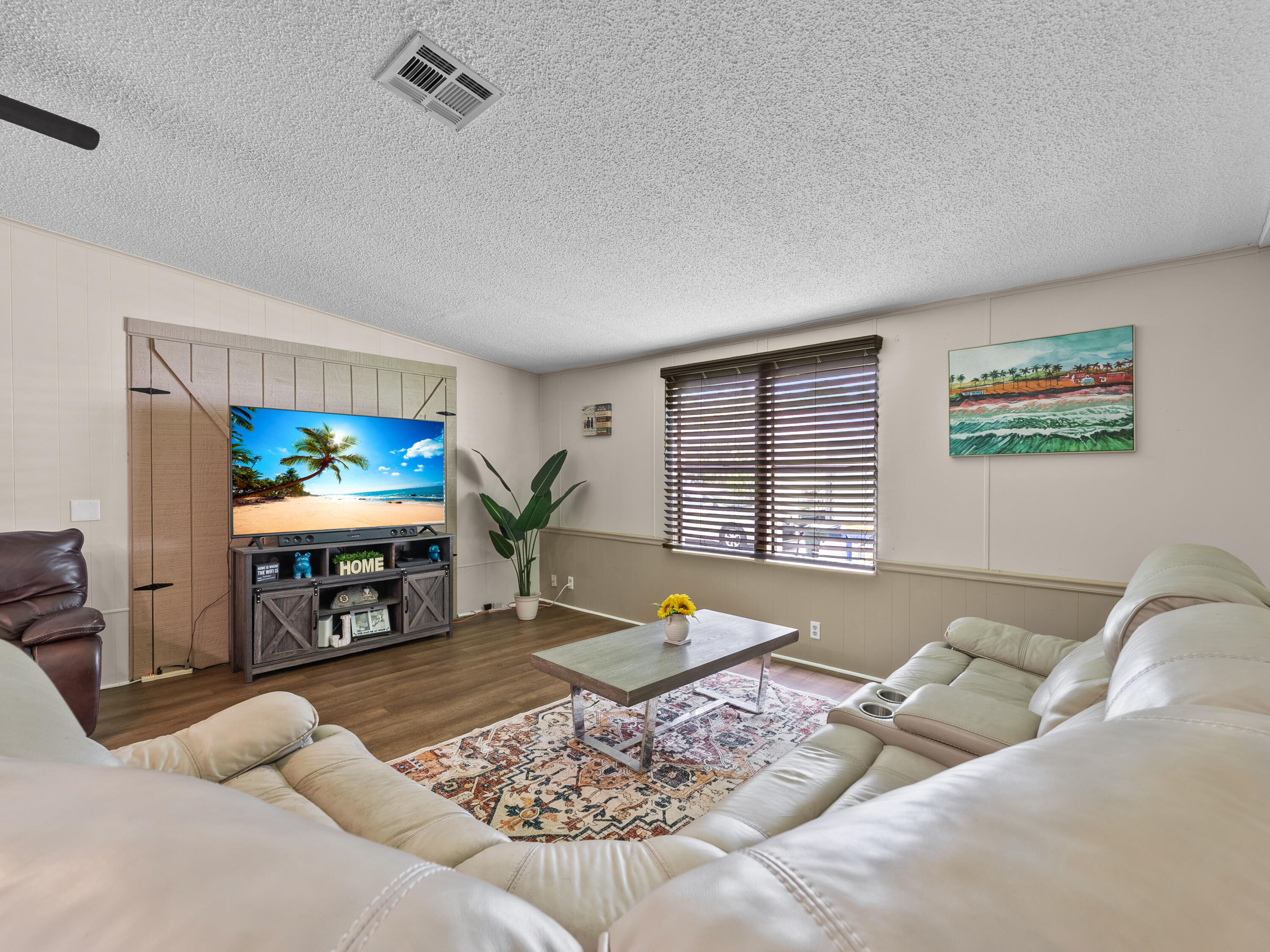 2855 Southwest Monarch Trail Stuart, FL 34997 - Photo 11 of 29 a living room with furniture a rug and a flat screen tv