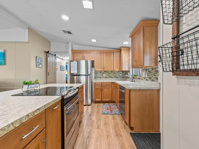 a kitchen with stainless steel appliances granite countertop a sink stove and refrigerator