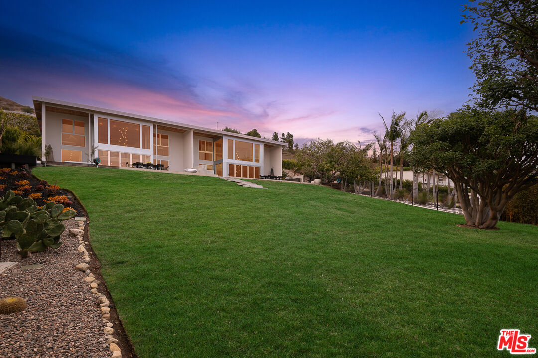 a front view of a house with a garden