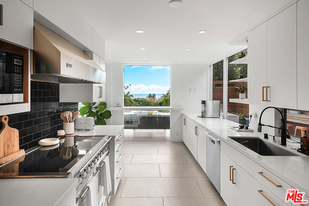 31201 Bailard Road Malibu, CA 90265 - Photo 12 of 56 a kitchen with a sink stove and cabinets