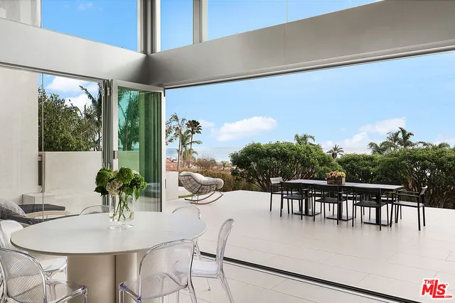 a dining room with furniture potted plants and wooden floor