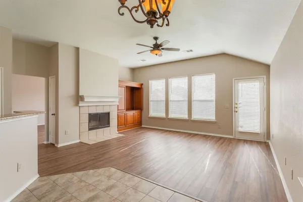 a view of an empty room with a kitchen and a window