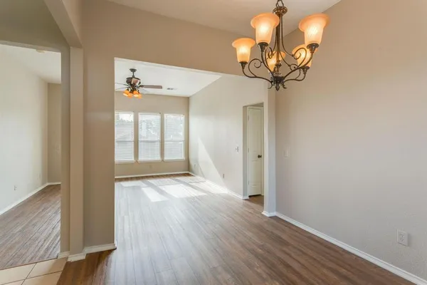 a view of a hallway with wooden floor and chandelier