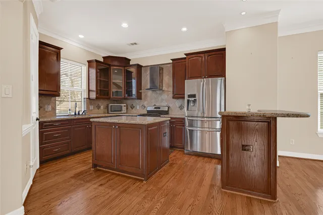 a kitchen with a refrigerator stove and wooden floor