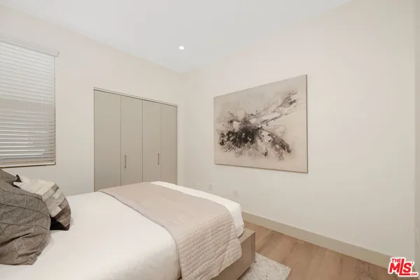 a bedroom with a bed and a painting on the wall