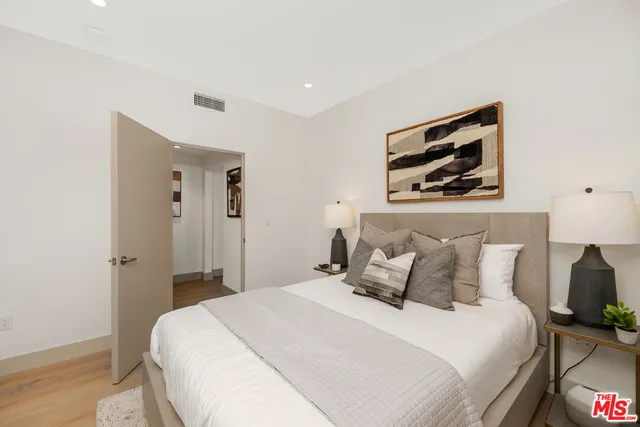 a bedroom with a bed and a painting on the wall