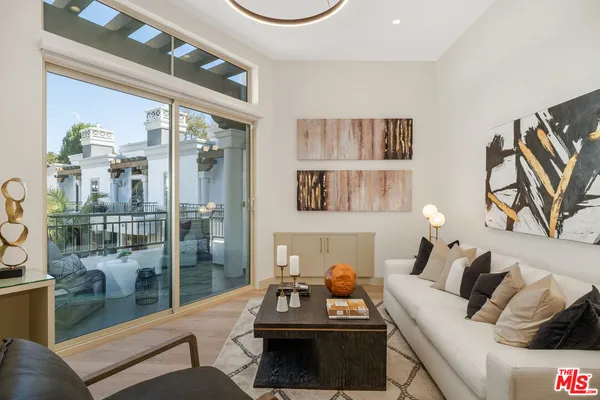 a living room with furniture and a floor to ceiling window