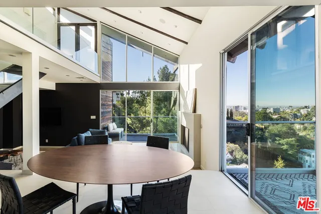 a dining room with furniture a rug and a floor to ceiling window