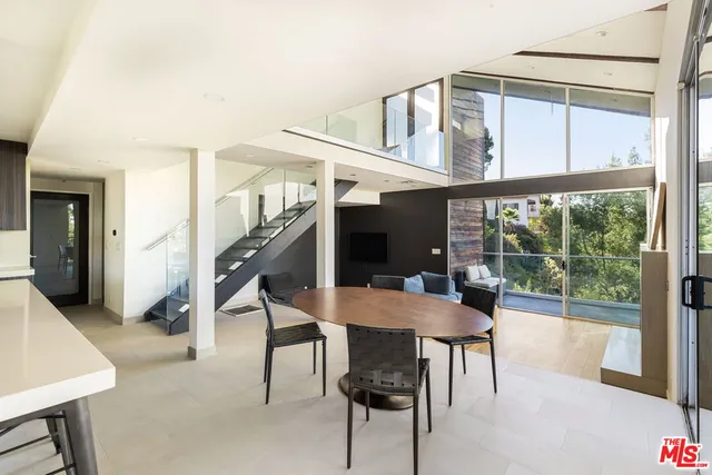 a dining room with furniture and a floor to ceiling window