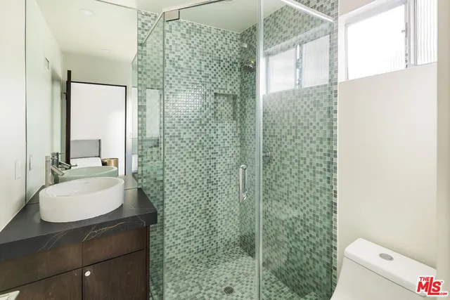 a bathroom with a sink a toilet and shower