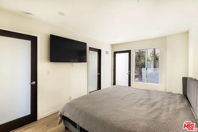 a bedroom with a large bed and a flat screen tv