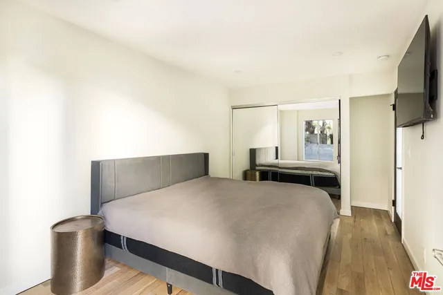 a bedroom with a bed and a flat screen tv