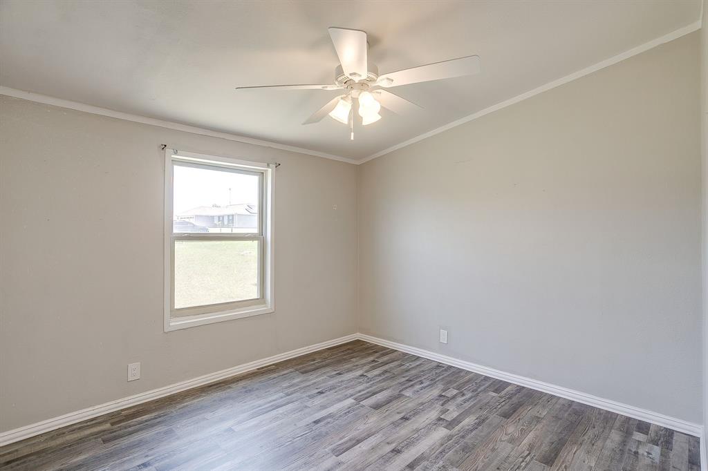 178 Valley Lake Lane Springtown, TX 76082 - Photo 23 of 33 Room featuring wood-finish flooring, neutral wall tones, and white trim