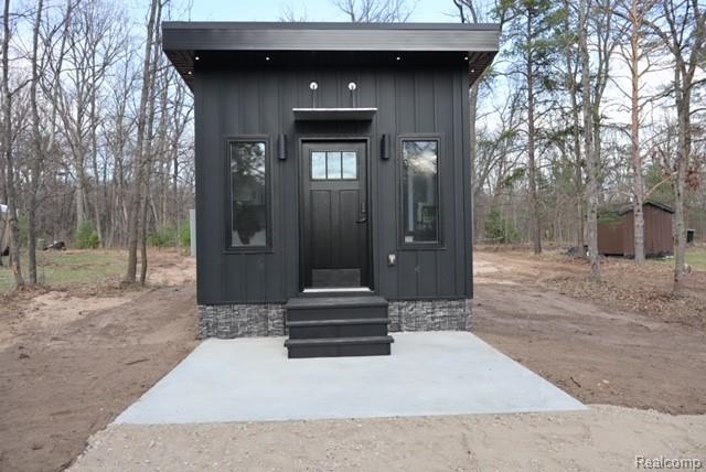 1545 South La Chance Road Lake City, MI 49651 - Photo 7 of 51 Doorway to property featuring board and batten siding
