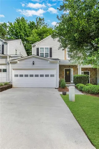 a view of house with outdoor space and a car park in front of it