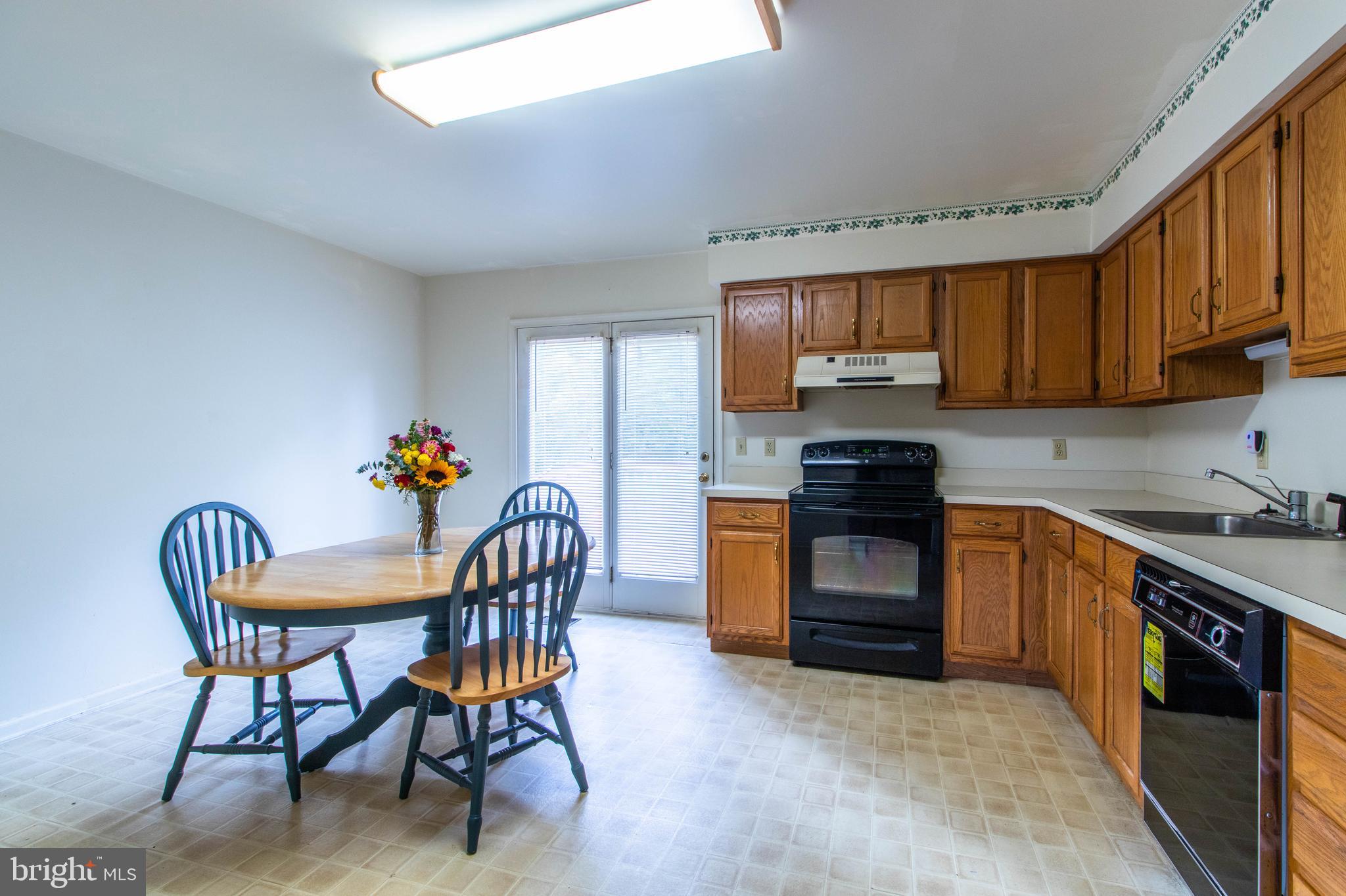 608 Rosedale Road Kennett Square, PA 19348 - Photo 5 of 30 a kitchen with stainless steel appliances granite countertop a stove top oven a sink a dining table and chairs