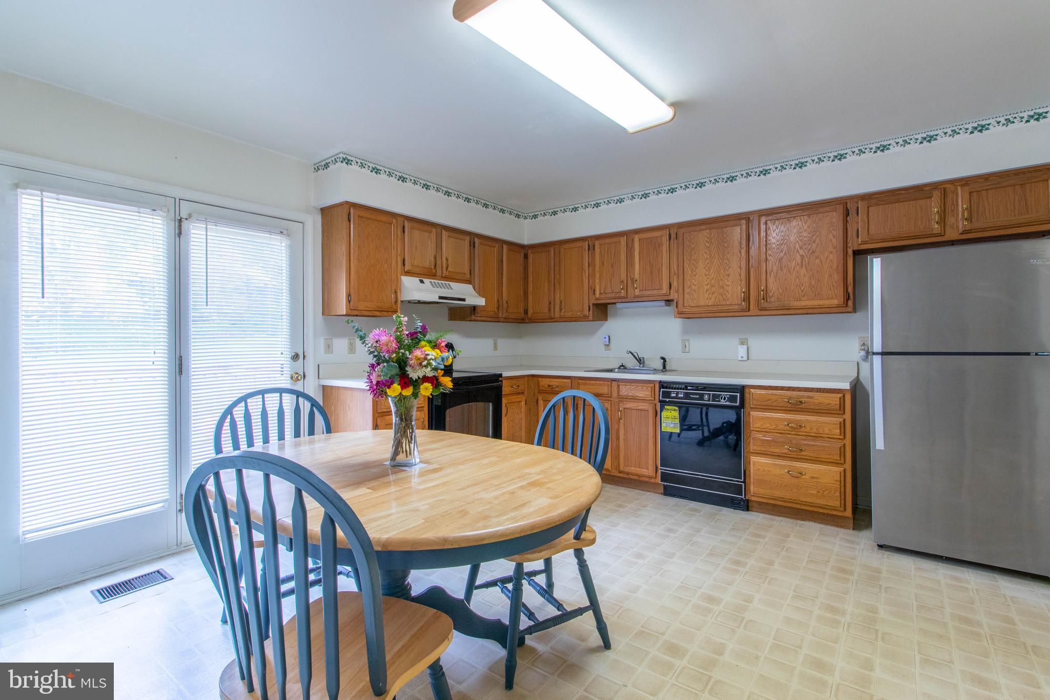 608 Rosedale Road Kennett Square, PA 19348 - Photo 7 of 30 a kitchen with granite countertop a refrigerator a stove a sink dishwasher and a dining table with wooden cabinet