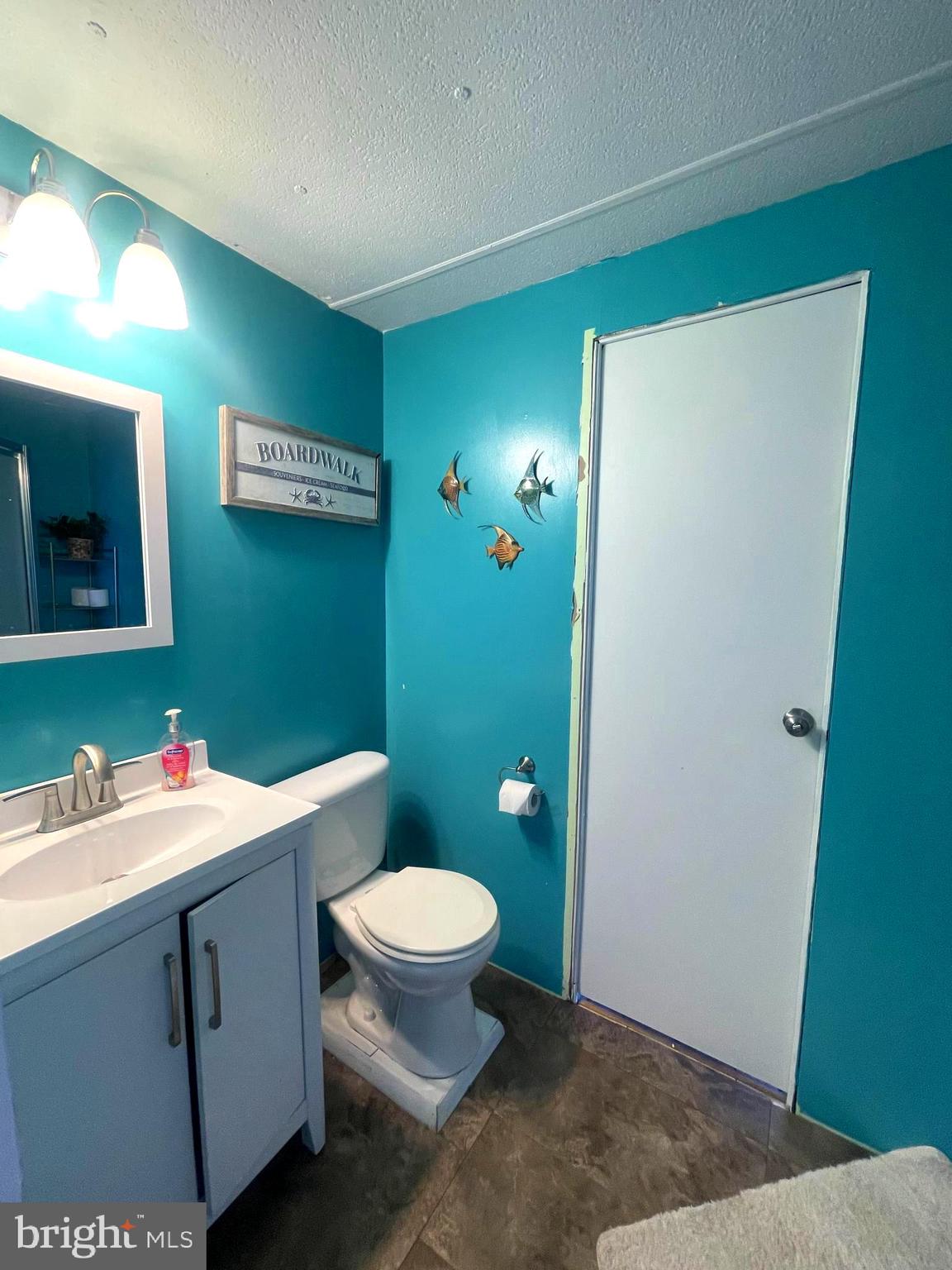 21720 B Street Rehoboth Beach, DE 19971 - Photo 12 of 23 a bathroom with a sink toilet and mirror
