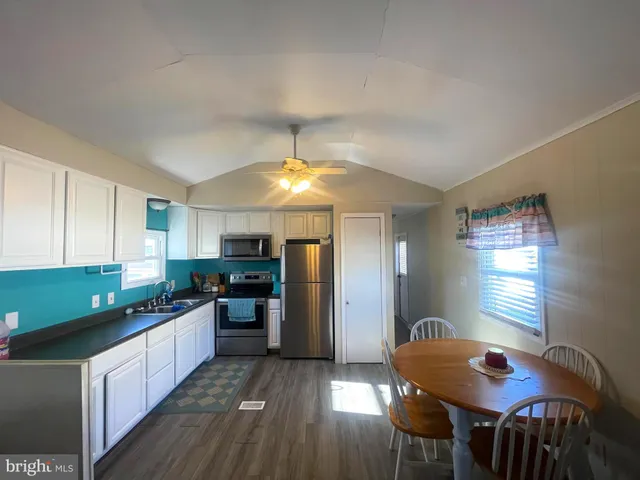 a kitchen with stainless steel appliances granite countertop a stove refrigerator and a sink