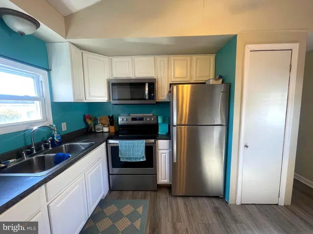 a kitchen with a refrigerator stove and sink