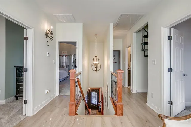 a view of a hallway with wooden floor and dining room view