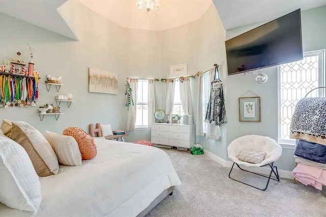 a bedroom with a bed and a chandelier