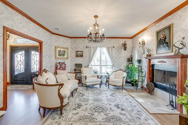 a living room with furniture chandelier and a fireplace