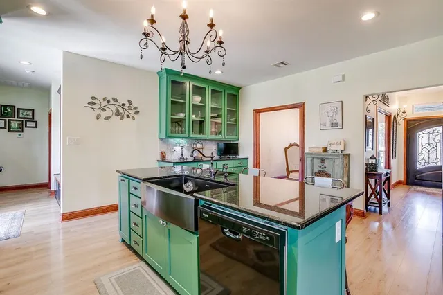 a kitchen with stainless steel appliances granite countertop a stove a sink and a refrigerator