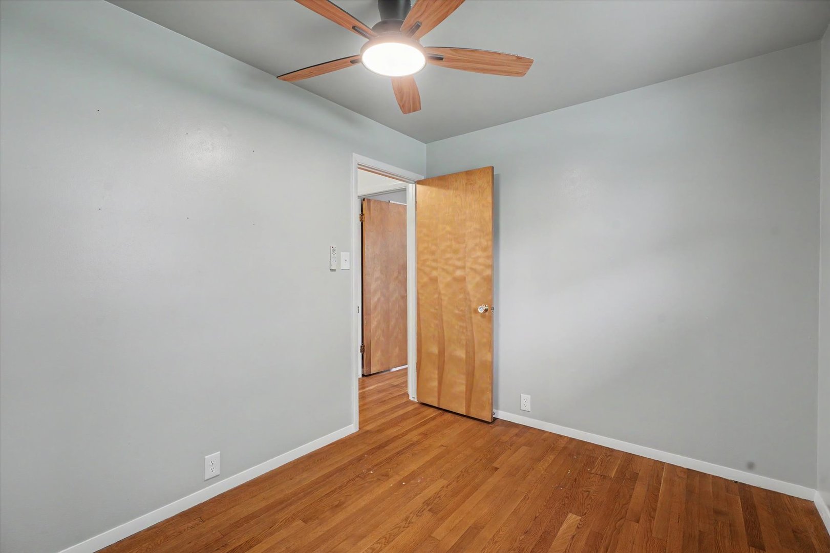 1605 Grange Drive Rantoul, IL 61866 - Photo 17 of 26 an empty room with wooden floor fan and windows