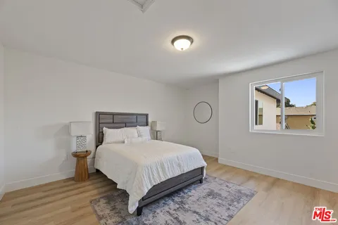 a bedroom with a bed and painting on the wall